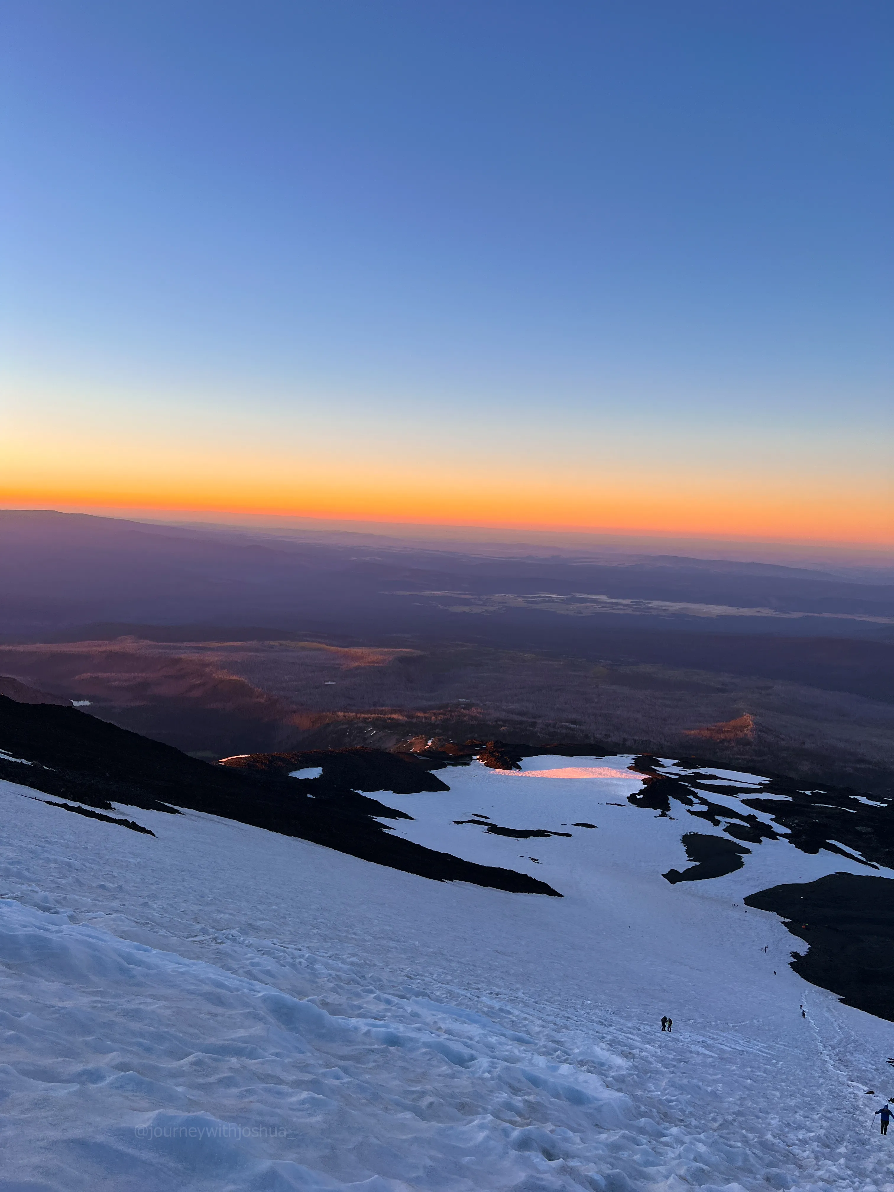 Alpenglow at sunrise on the steep snow of Mount Adams