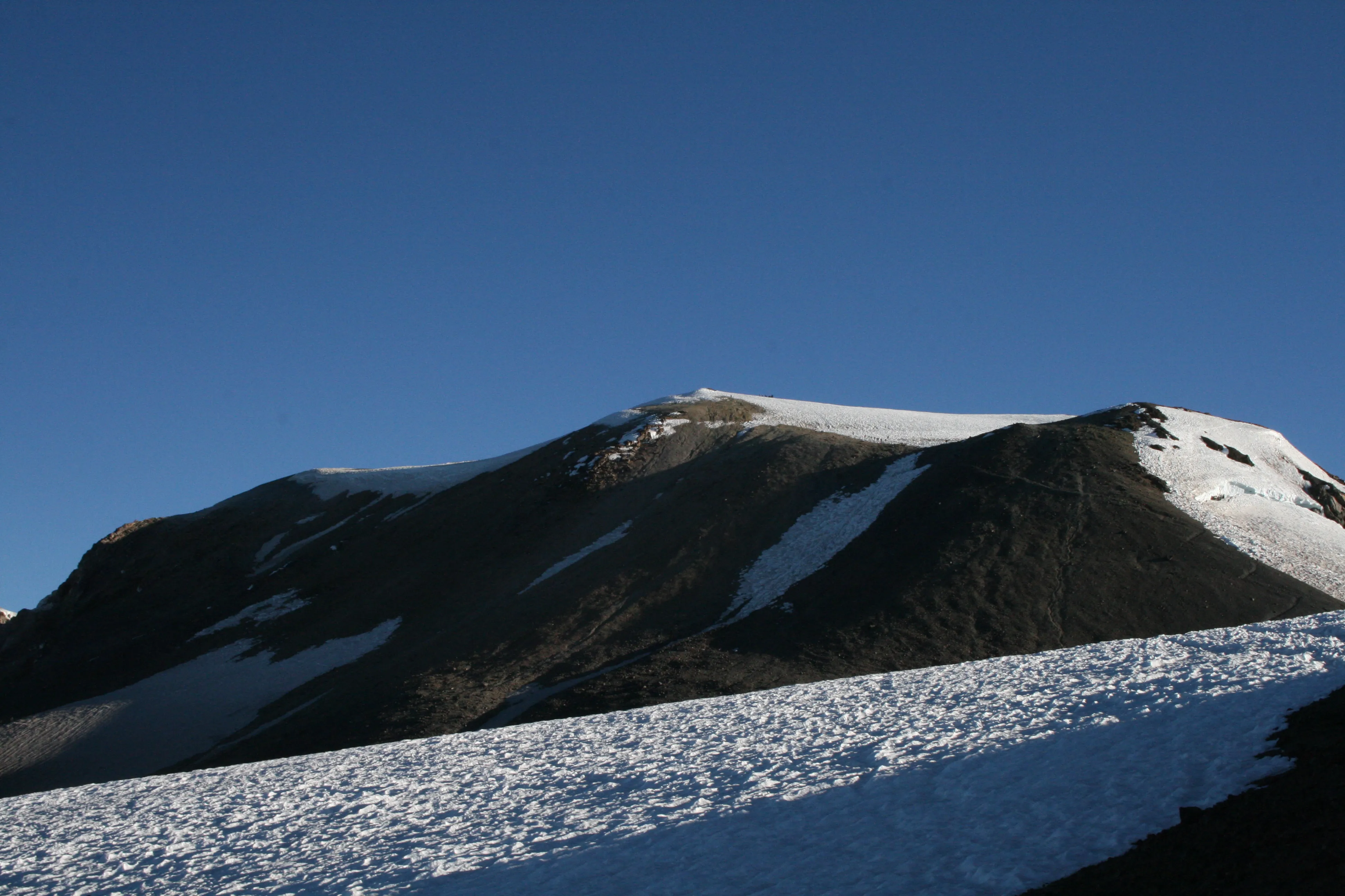 The vast summit of Mount Adams with tiny climbers for scale