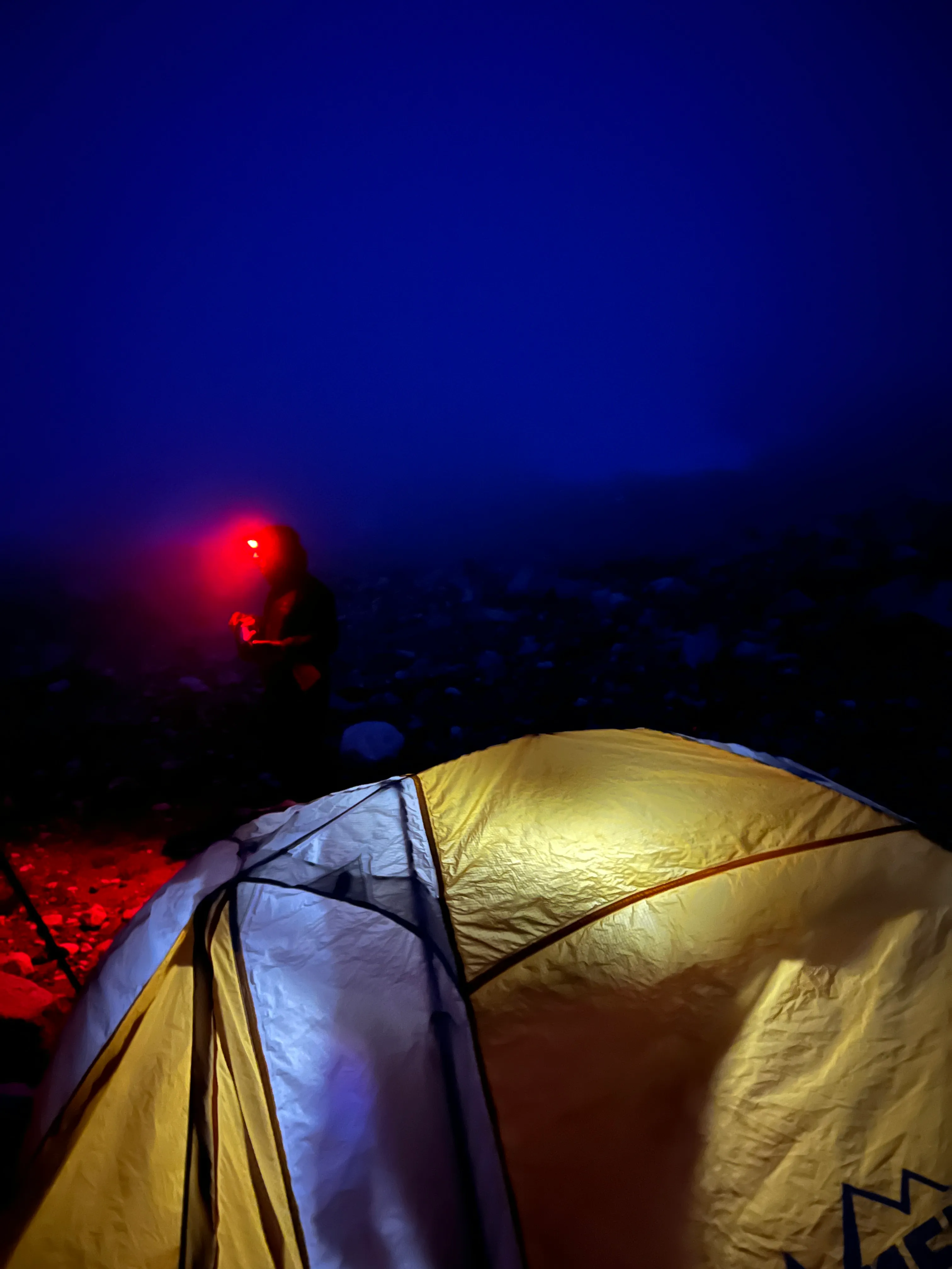 Our boulder camp under red headlamp light, socked in with fog on the first night