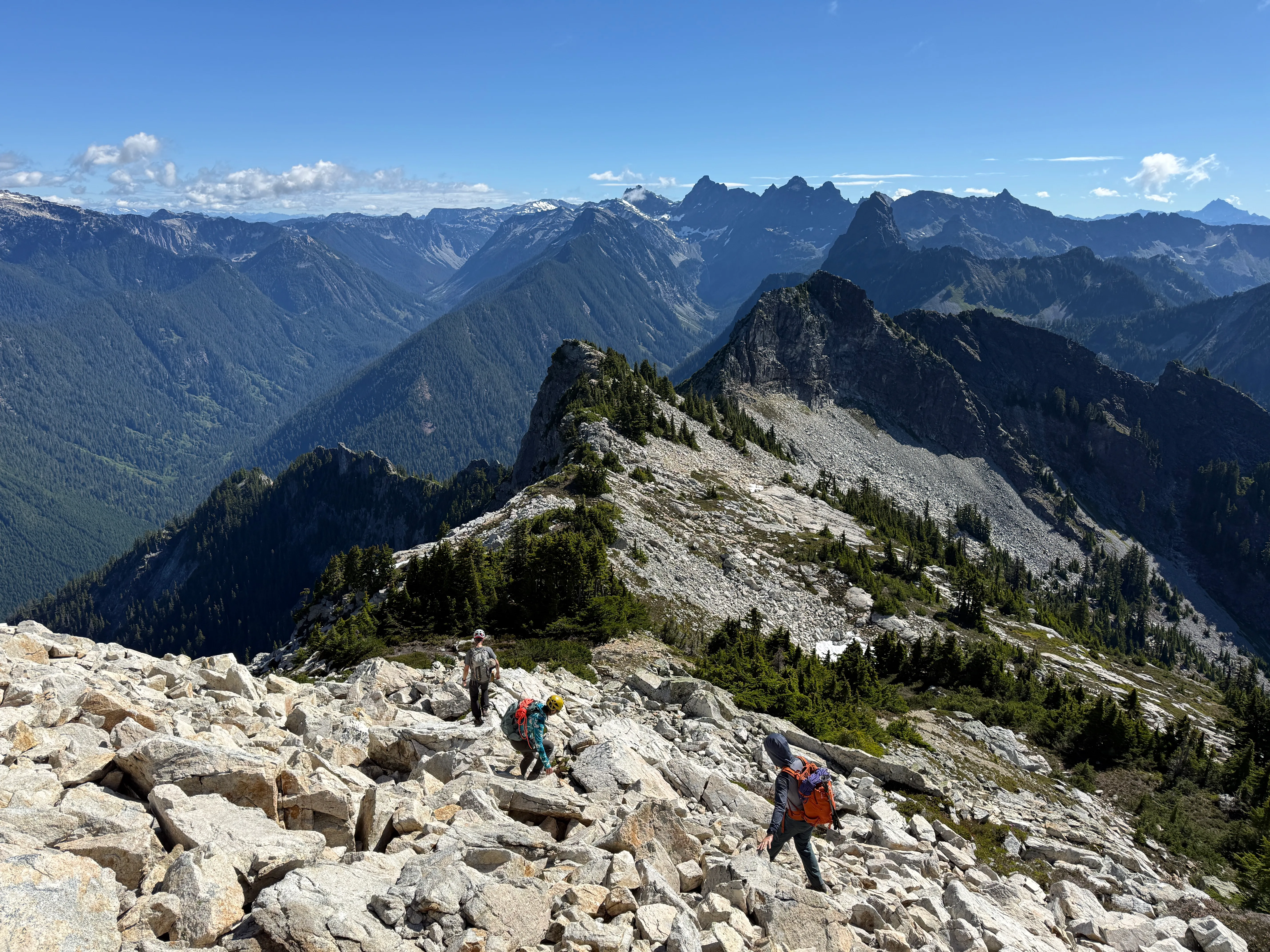 The team working along the talus with Lundin Peak coming into view