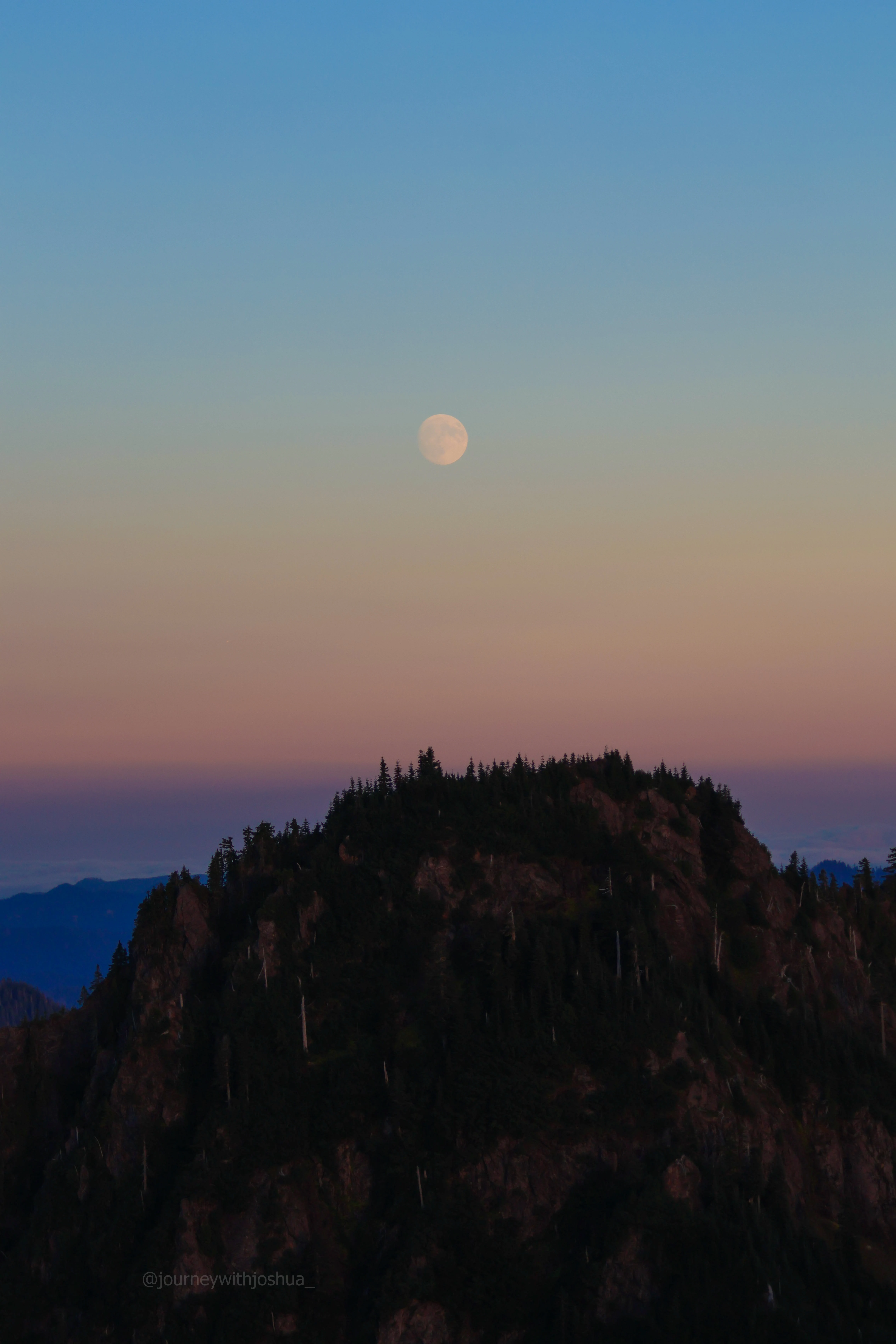 Moonrise over a peak in the Olympic Range.