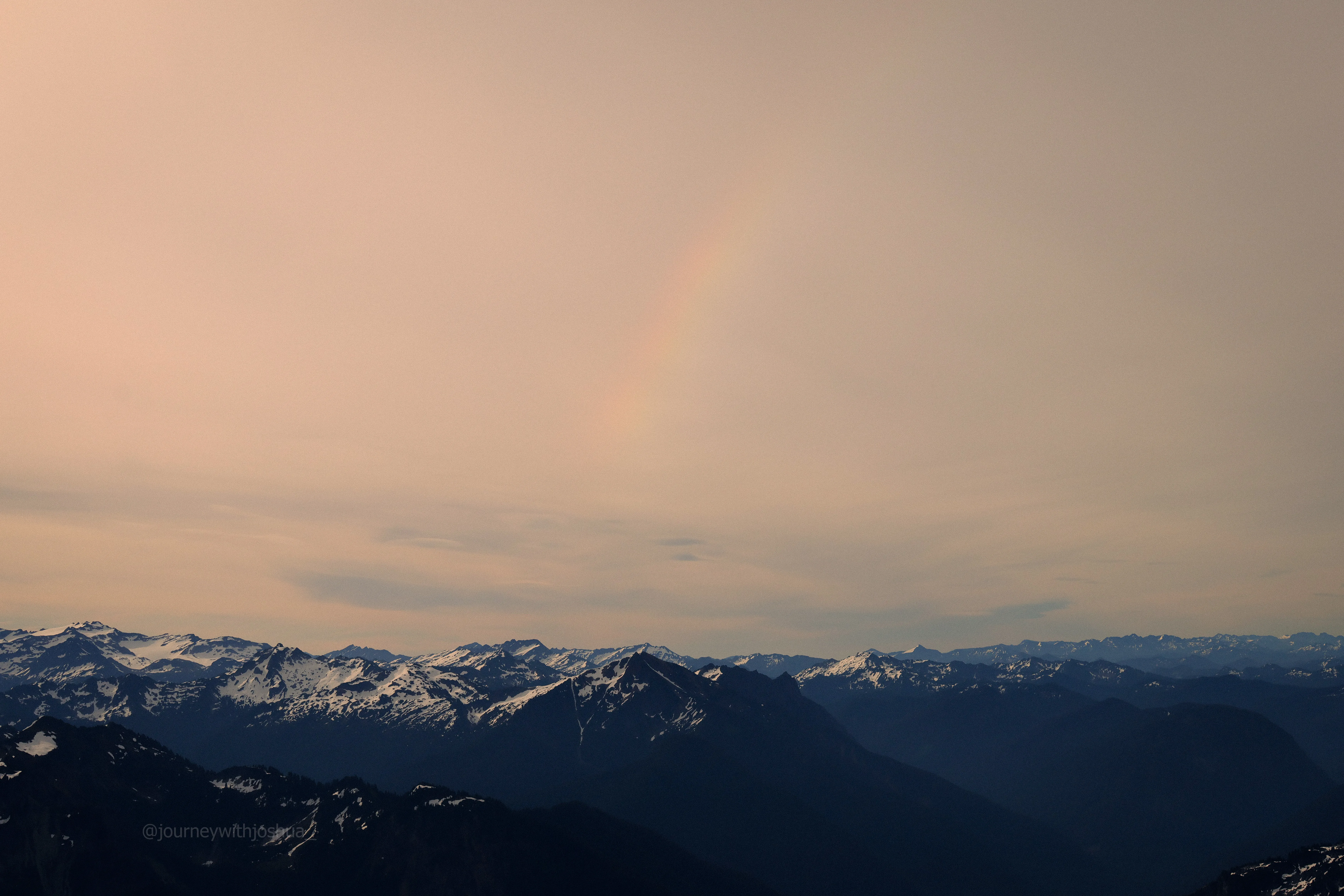 A rainbow and clouds over the North Cascades from Mount Pugh.