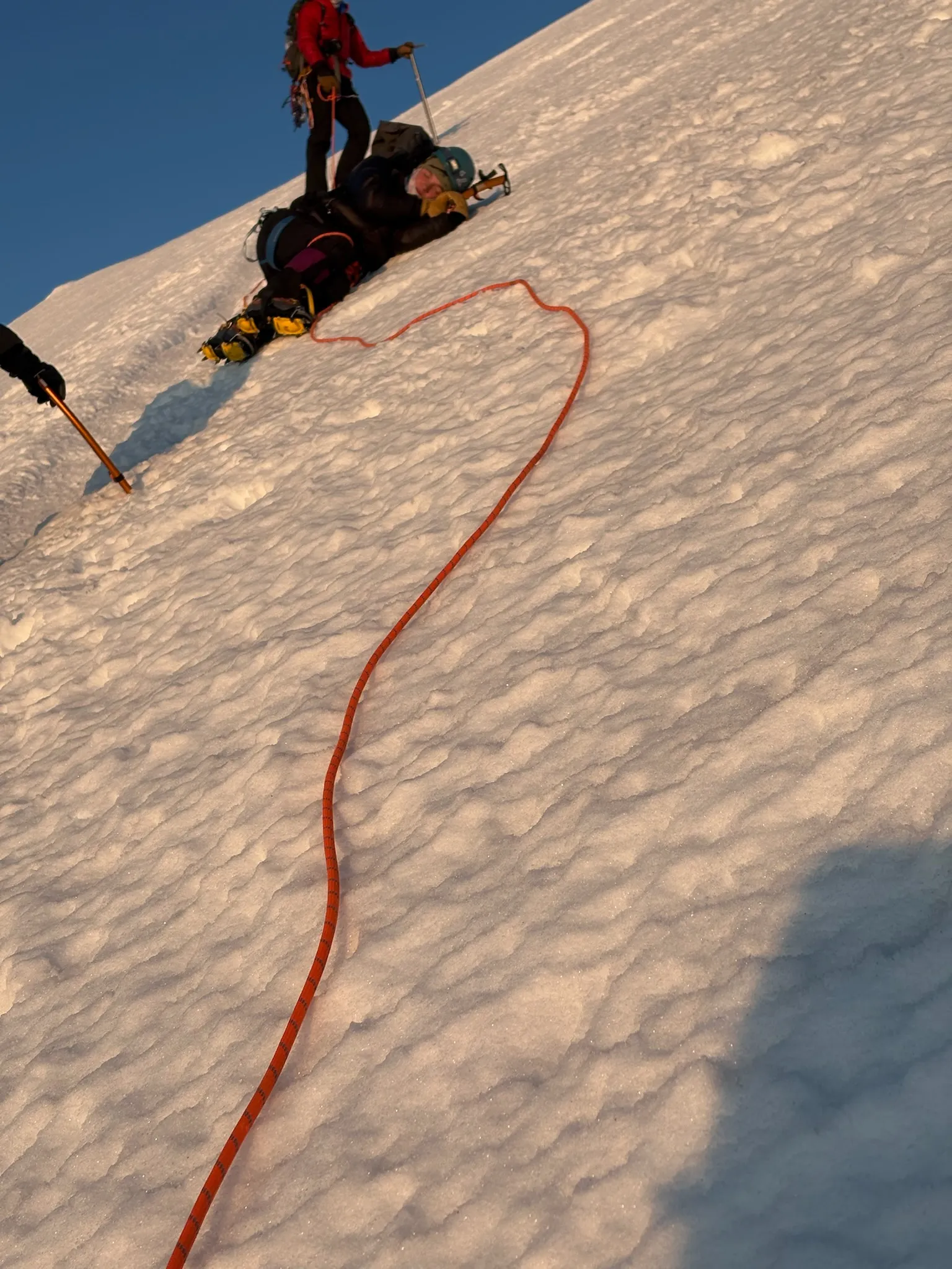 A climber lying down for a quick rest on the glacier