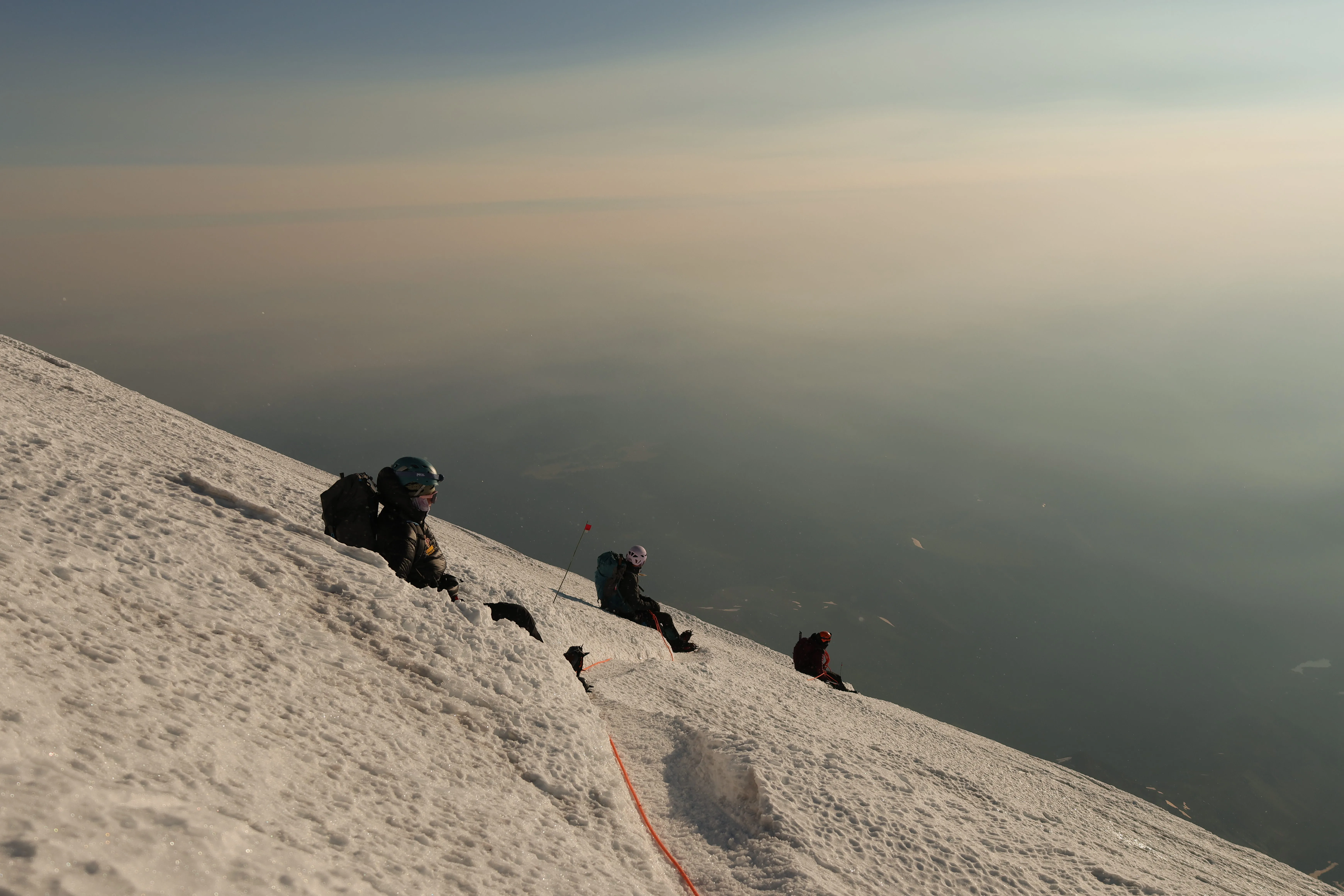 The team resting at the summit with smoke in the valley below