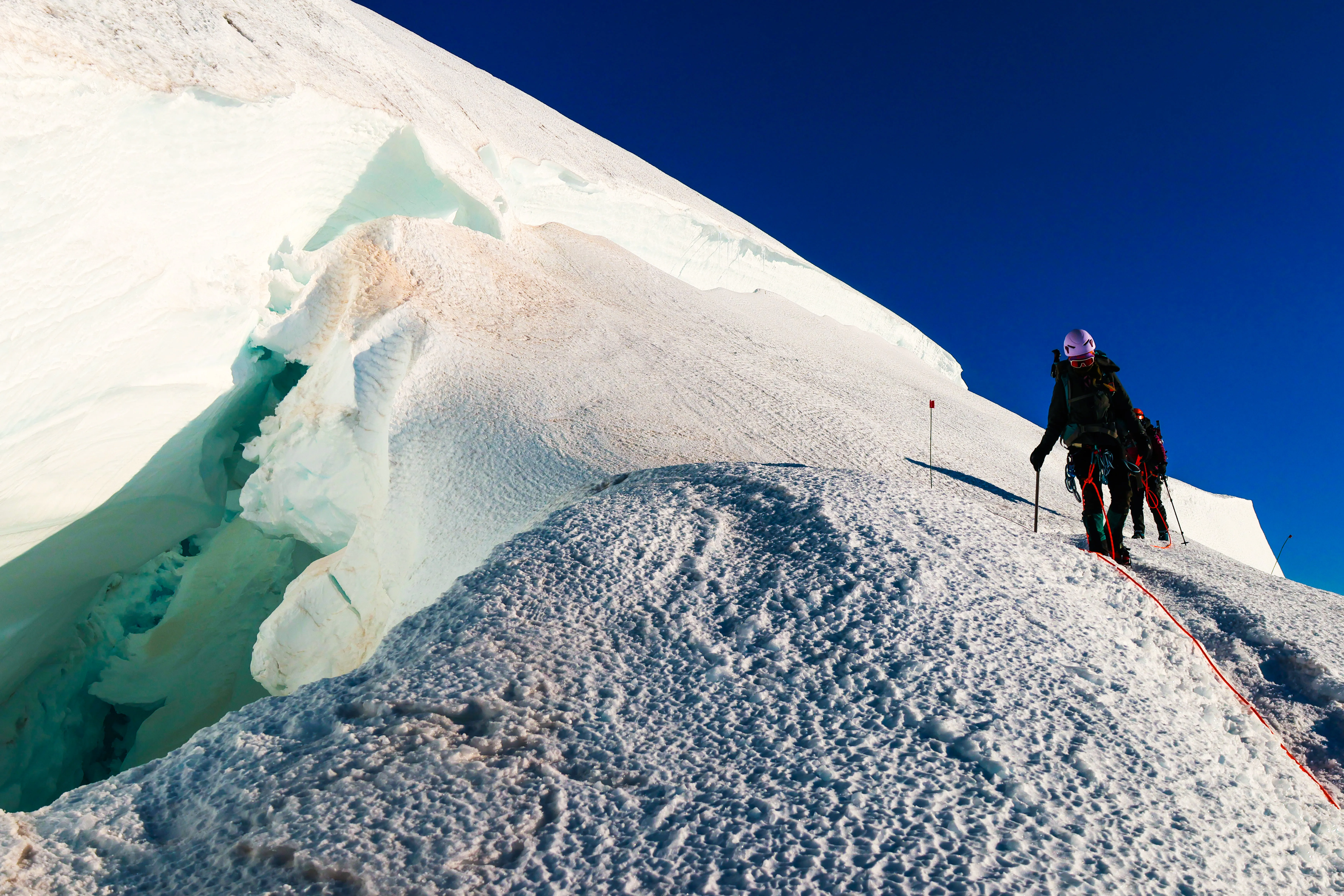 The team navigating a large crevasse on the descent