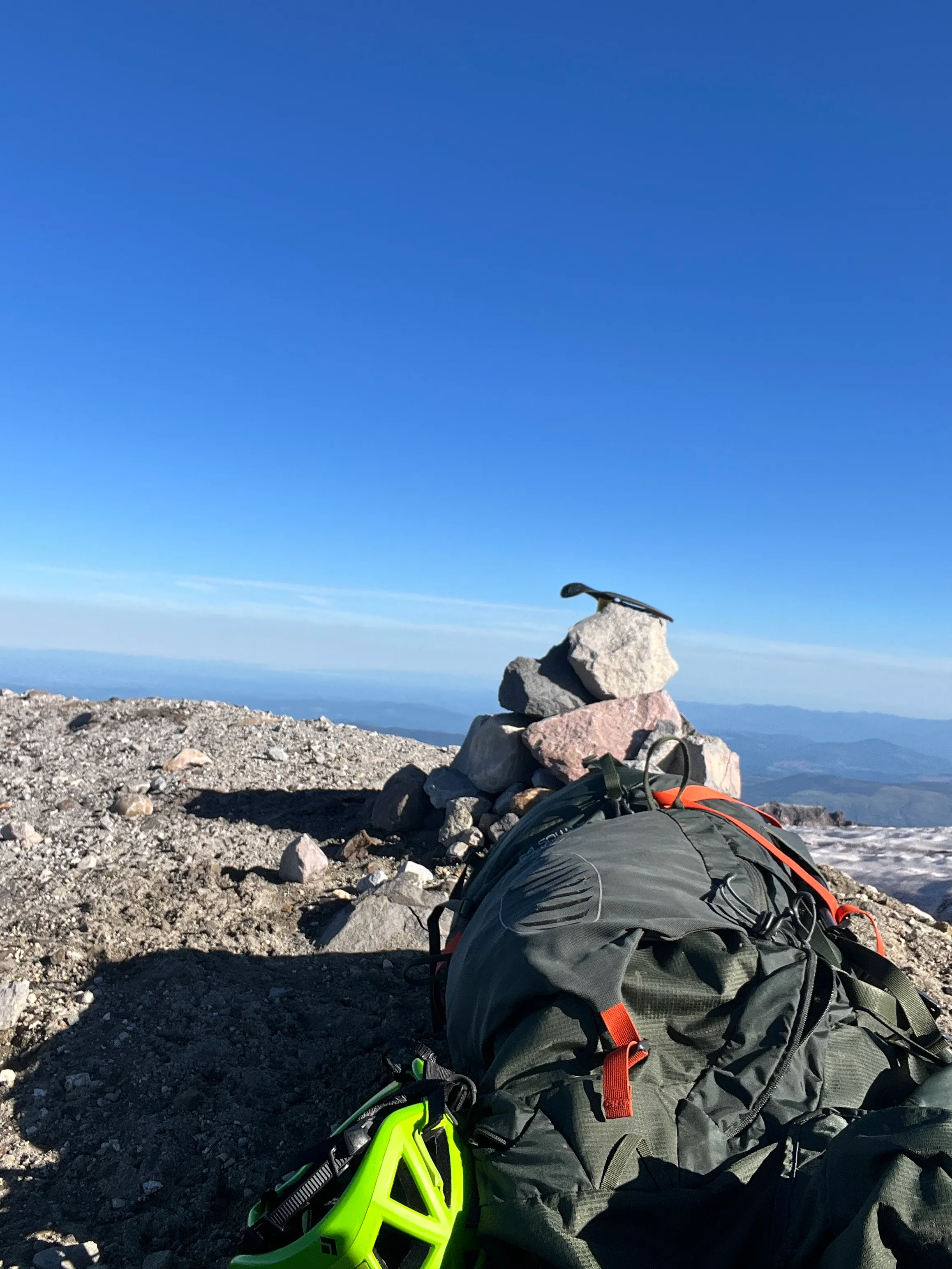 At the true summit of Mount St. Helens, a pile of rocks and a tired climber