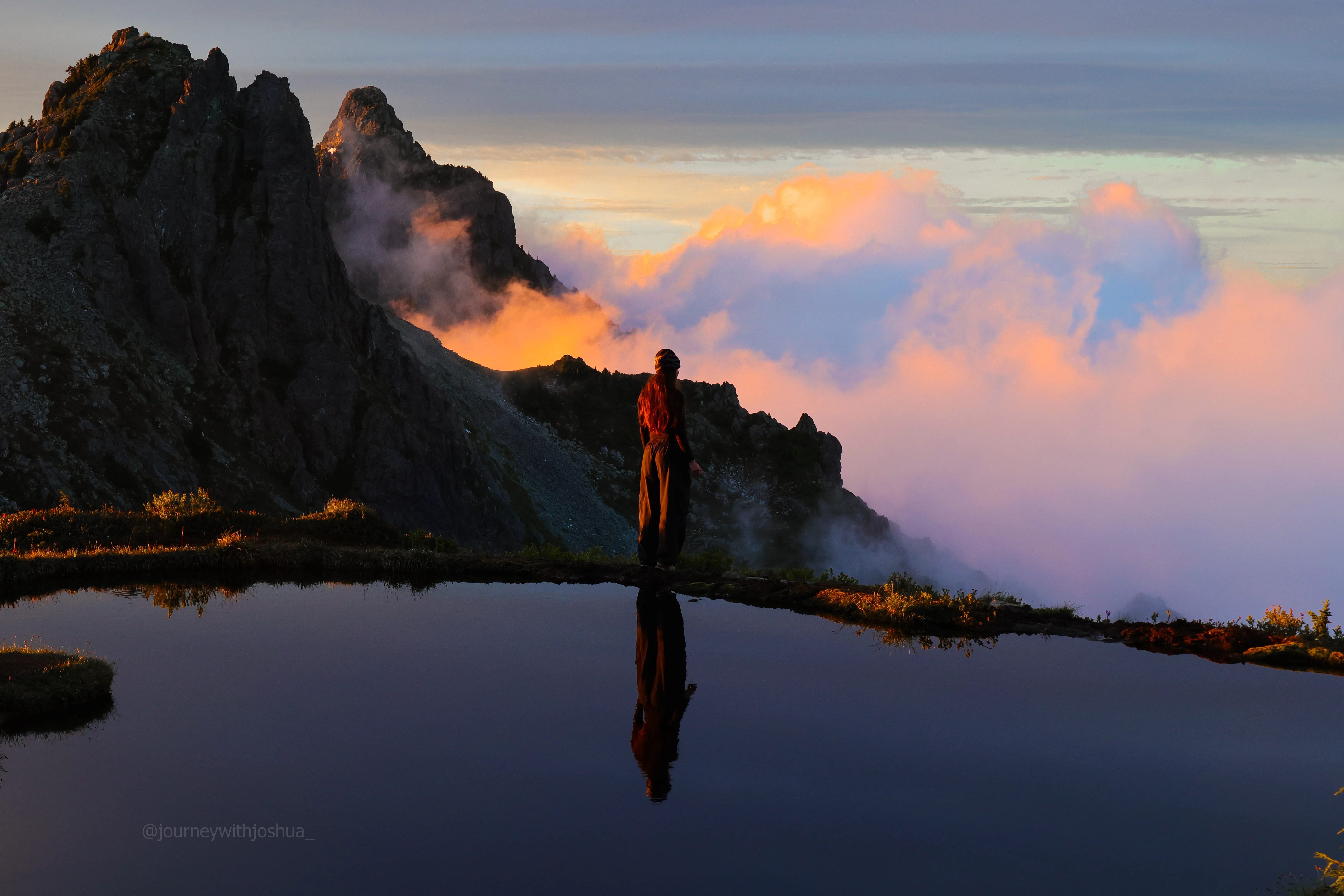 Haley reflected in the still tarn with Wing and Merchant peaks behind