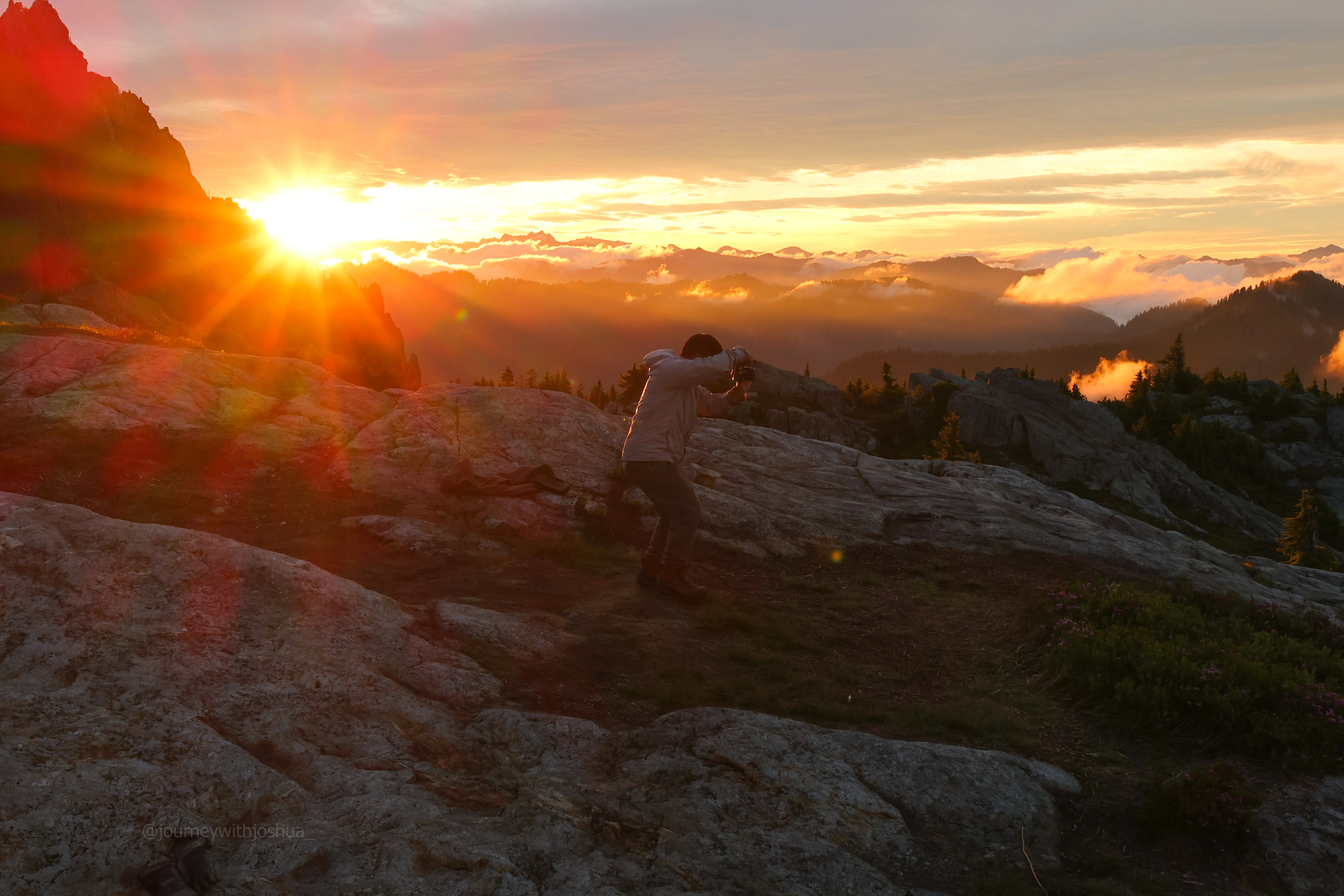 Tony snapping photos as the sunrise peaks over the peaks