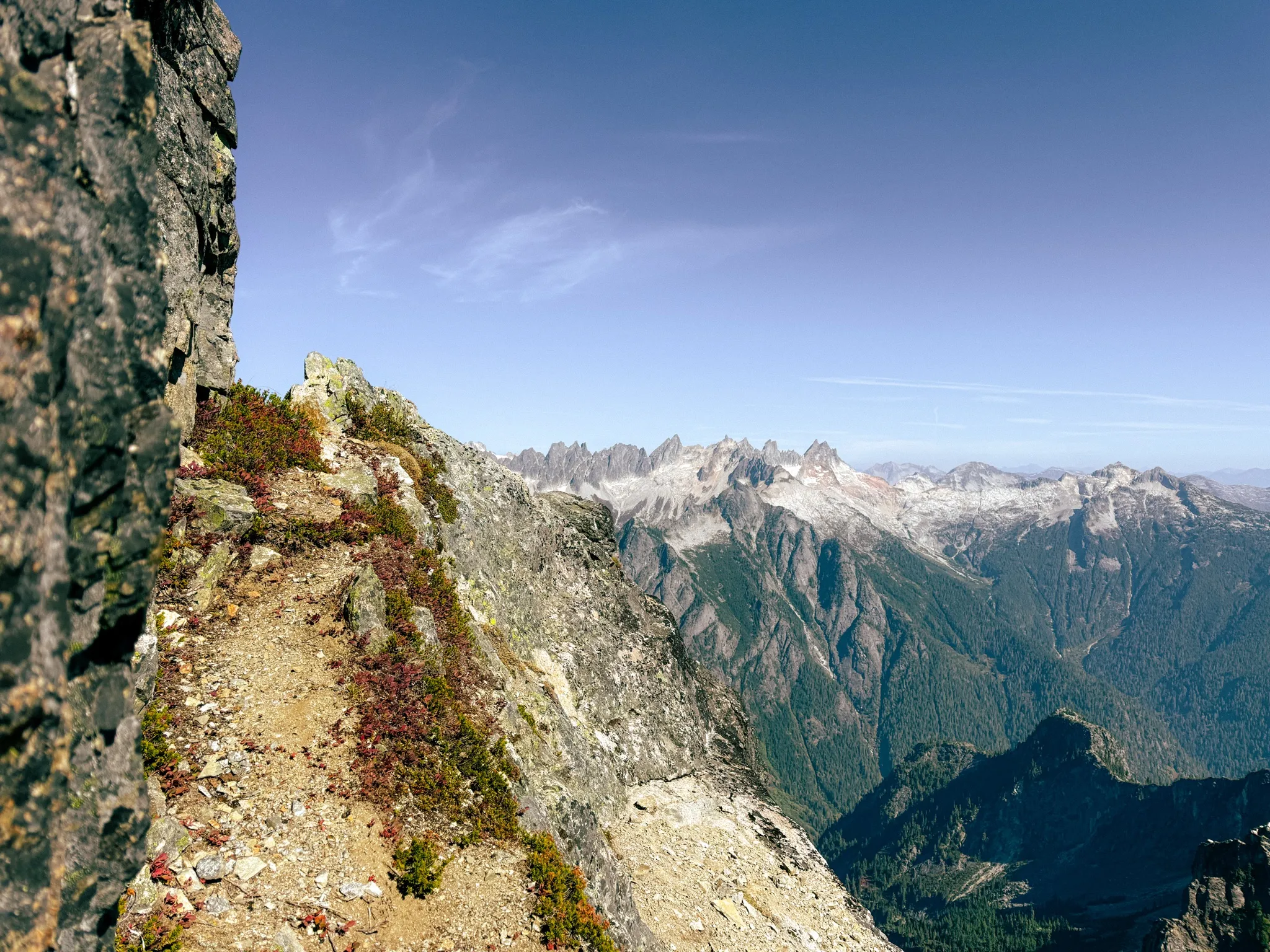 Onto the heather ledges with the Picket Range in the distance on Mount Triumph